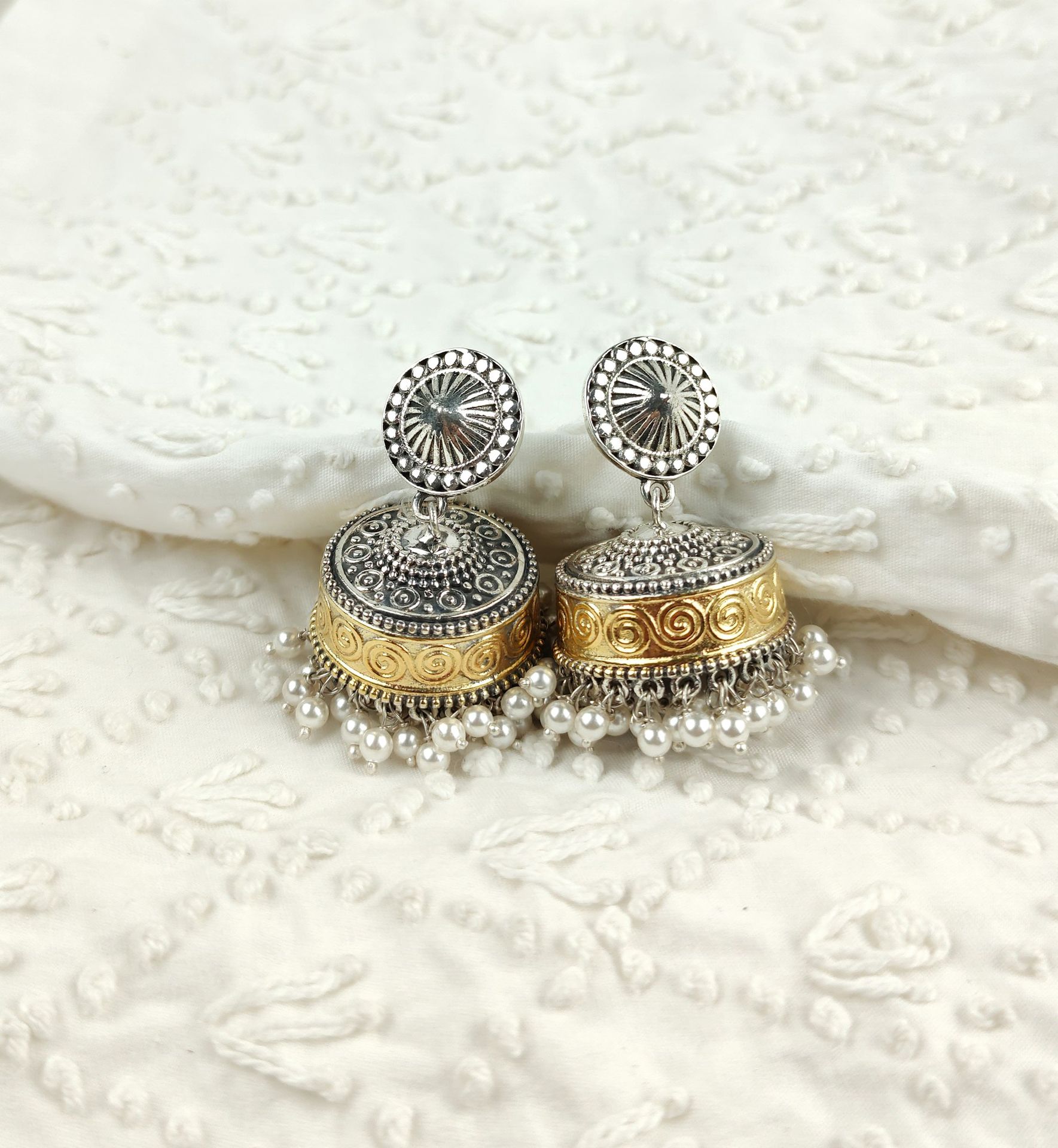 a pair of silver and gold earrings